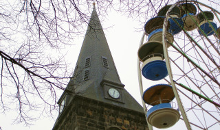 Torre de iglesia y noria entre ramas desnudas en Haaksbergen, Overijssel, Países Bajos, en un día nublado.
