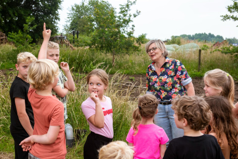 Niños y adulta participan en actividad al aire libre en FarmCamps Den Branderhorst, Gelderland, Países Bajos.