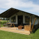 Safari telt ved Farm Campsite the Katreel, med træterrasse og picnicbord på en grøn græsplæne.