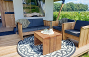 Outdoor seating area at the safari tent of Farm Campsite the Katreel in the Netherlands, with wooden furniture.