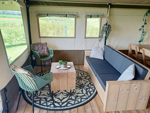 Interno di una tenda safari a Farm Campsite the Katreel nei Paesi Bassi con mobili in legno e decorazioni.