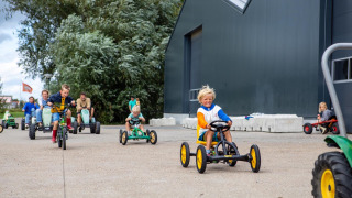 Niños jugando en karts a pedales en FarmCamps De Kamperhoek, parque vacacional en Zeeland, Países Bajos.
