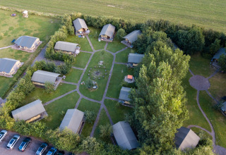 Luchtbeeld van FarmCamps De Kamperhoek vakantiepark in Zeeland, Nederland, met lodges en groene zones.