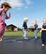 Niños saltando con alegría en una cama elástica en FarmCamps Alpaca Vorstenbosch, Brabante Septentrional.