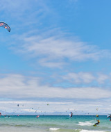 Kitesurfistas disfrutan del mar y el cielo azul en TAIGA Tarifa, un parque vacacional en Andalucía, España.