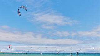 Kitesurfistas disfrutan del mar y el cielo azul en TAIGA Tarifa, un parque vacacional en Andalucía, España.