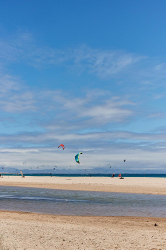 Plage de sable à TAIGA Tarifa, Andalousie, Espagne, avec des kitesurfeurs sous un ciel bleu.