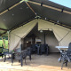 Safaritent op Camping de Regenboog in Tsjechië met houten veranda, zitplaatsen en uitzicht op natuur.