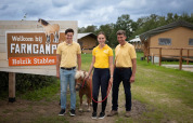 Tre mennesker og en lille pony står foran et FarmCamps-skilt ved Holzik Stables i Overijssel, Holland.