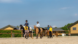 Niños reciben clases de equitación con instructores en FarmCamps Holzik Stables en Overijssel, Países Bajos.