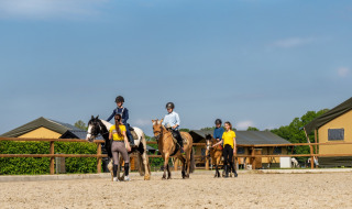 Niños reciben clases de equitación con instructores en FarmCamps Holzik Stables en Overijssel, Países Bajos.