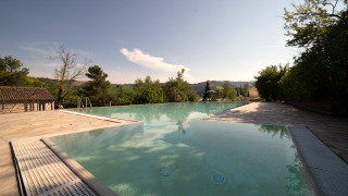 Infinity pool bij Camping Podere Sei Poorte in Marche, Italië, met uitzicht over heuvels en groene natuur.