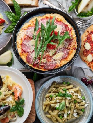 Selección de platos italianos como pizza y pasta, fotografiada cerca de Monteciccardo en la región de Marche, Italia.