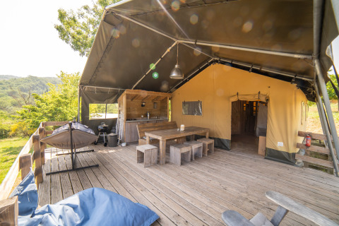 Safari Lodge tent met privébadkamer en groot houten terras op Camping Podere Sei Poorte in Italië