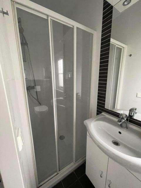 Bagno con doccia e lavandino nella Comfort Lodge al Kompas Camping Westende, Belgio, cani ammessi.