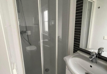 Salle de bain avec douche et lavabo dans Comfort Lodge au Kompas Camping Westende, Belgique, chiens admis.
