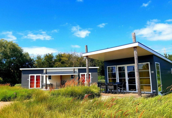 Zwei moderne Comfort Lodge-Hütten im Grünen unter blauem Himmel, hundefreundlich und gemütlich