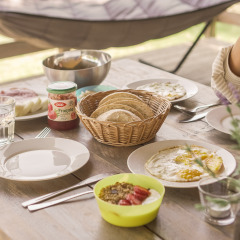 Breakfast table at Camping Les Sapins in Occitanie, France with bread, eggs, jam, coffee and fruit bowl.