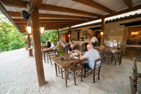 Buitenrestaurant aan Camping Podere Sei Poorte in Marche, Italië, waar gasten samen dineren.