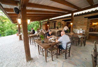 Buitenrestaurant aan Camping Podere Sei Poorte in Marche, Italië, waar gasten samen dineren.