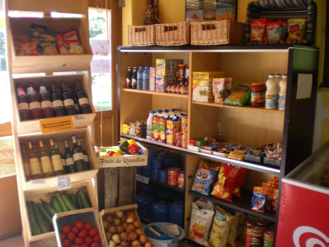 Una variedad de comestibles, vino y productos frescos en una pequeña tienda del Camping Les Sapins, Occitanie, Francia.