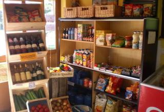 Una variedad de comestibles, vino y productos frescos en una pequeña tienda del Camping Les Sapins, Occitanie, Francia.