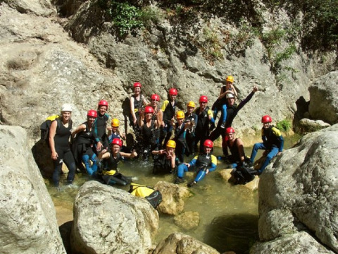 Groep kampeerders met helmen en wetsuits op avontuur bij Camping Les Sapins in Occitanie, Frankrijk.