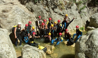 Grupo de campistas con cascos y trajes de neopreno en una aventura en Camping Les Sapins, Occitanie.