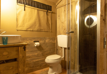 Badkamer van de safaritent Wood Lodge op Camping Al Lago di Lago in Italië met houten accenten.