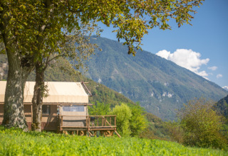 Desert Lodge XL safari tent at Camping Gajole in Italy, surrounded by lush greenery and scenic mountains.