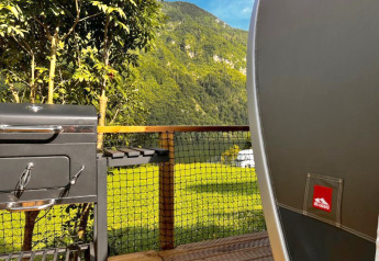 Blick aus dem Safari-Zelt Big Oak Lodge mit Grill und Terrasse vor grünen Bergen und Wäldern.
