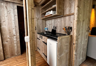 Pequeña cocina del safari-tienda Big Oak Lodge con mini nevera, fregadero y utensilios de cocina.