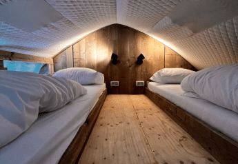 Interno della tenda safari Big Oak Lodge con due letti singoli, pannelli in legno e soffitto trapuntato.