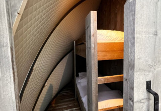 Binnenzicht van de Big Oak Lodge safaritent, met stapelbedden en gebogen, gevoerde muren.