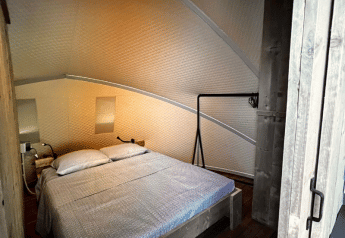 Dormitorio en la tienda safari Big Oak Lodge con cama doble, paredes de madera y ambiente acogedor.