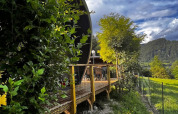 View of the Big Oak Lodge safari tent, surrounded by lush trees and mountains under a striking sky.