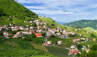 Pueblo rodeado de colinas verdes y viñedos cerca de Arsiè, Véneto, Italia, en un día soleado.