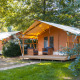 Safari-Zelt Slow Lodge auf dem Campingplatz Seasonova du Chêne in Frankreich, umgeben von Bäumen und Grün.