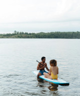 Zwei Menschen sitzen auf einem Paddleboard auf dem Wasser bei Saint-Julien-de-Concelles in Pays de la Loire, Frankreich.