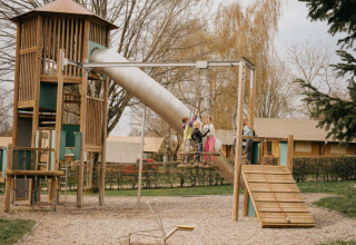 Bambini che giocano in un parco giochi con scivolo e altalene al Camping Belle-Vue 2000 a Echternach, Lussemburgo.