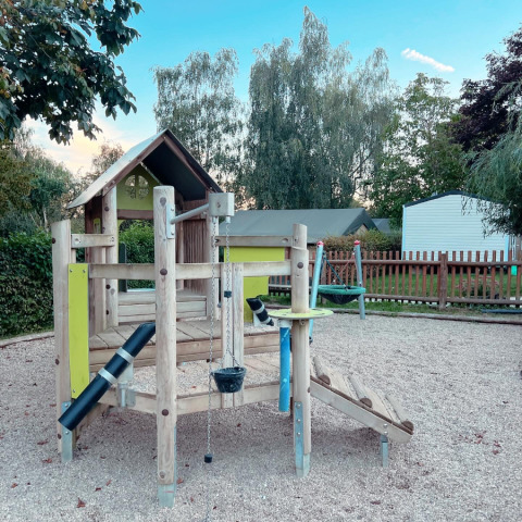 Playground at Camping Belle-Vue 2000 with wooden climbing structure and swings in Echternach, Luxembourg.
