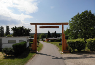 Indgangsport til Camping Belle-Vue 2000 feriepark i Echternach, Luxembourg med campingvogne og grønne omgivelser.