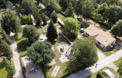 Aerial view of Camping Belle-Vue 2000 in Echternach, Luxembourg, showing playgrounds, trees, and main building.