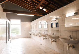 Salle de bains commune spacieuse avec lavabos et miroirs au Camping Belle-Vue 2000 à Echternach, Luxembourg.