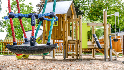 Parco giochi colorato con altalene e casetta in legno a Camping Belle-Vue 2000, Echternach, Lussemburgo.