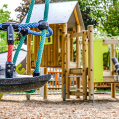 Colorido parque infantil con columpios y casa de madera en Camping Belle-Vue 2000, Echternach, Luxemburgo.