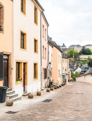 Calle adoquinada con casas coloridas cerca de Berdorf, Echternach, Luxemburgo, en un día nublado.