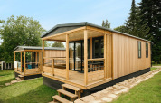 Moderne træchalet Mobilhome O'Hara Living på Camping Belle-Vue 2000 i Luxembourg omgivet af grøn natur.