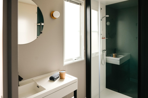 Modernes Badezimmer im Mobilhome O'Hara Living auf Camping Belle-Vue 2000 in Luxemburg mit Spiegel und Dusche.