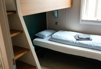 Habitación en Mobilhome O'Hara Living con literas, escalera y ventana en Camping Belle-Vue 2000 en Luxemburgo.